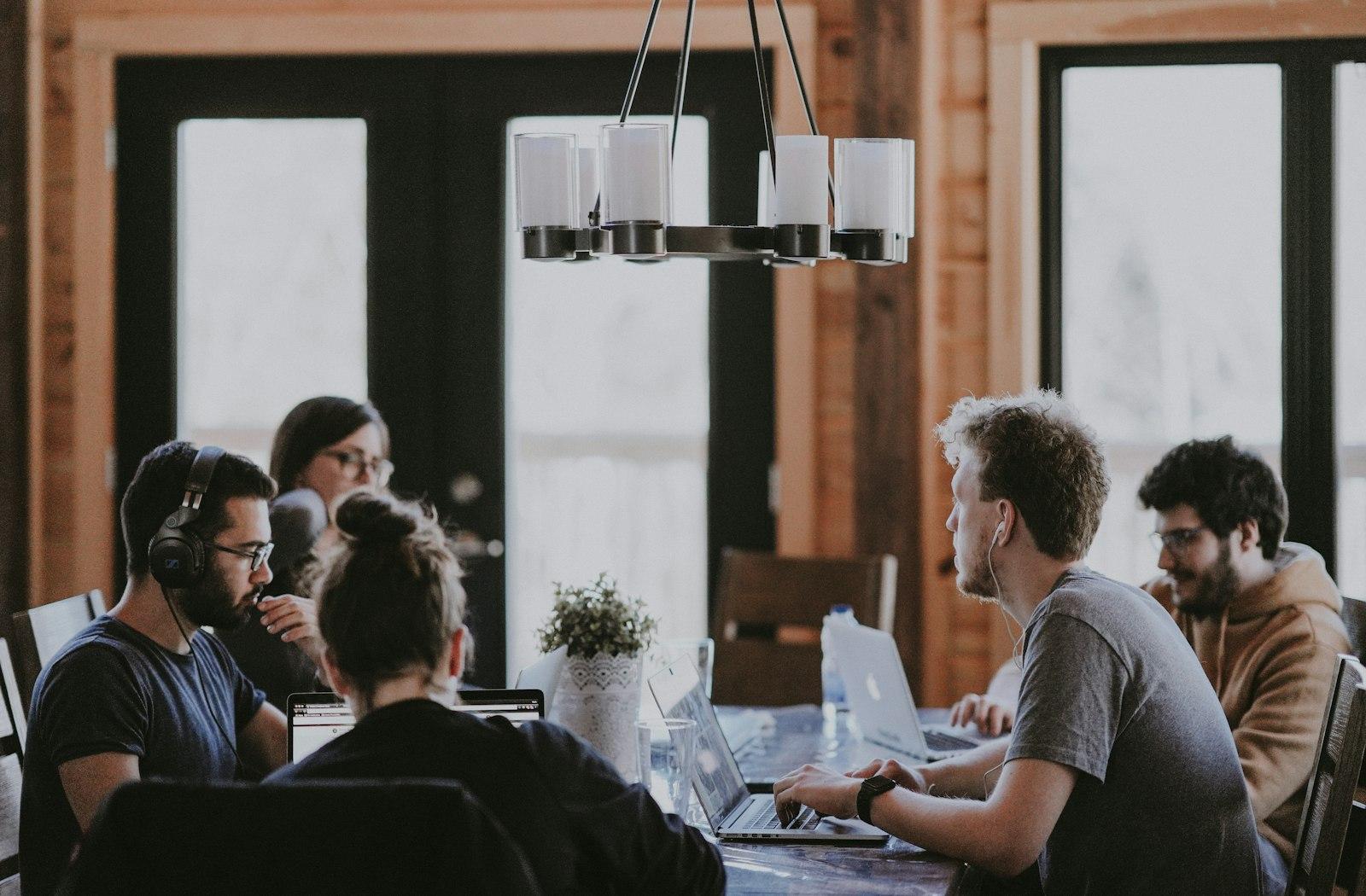 A small team working together around a table with laptops